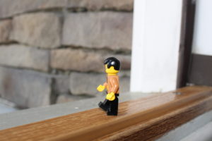 Lego Figure stepping out front door.